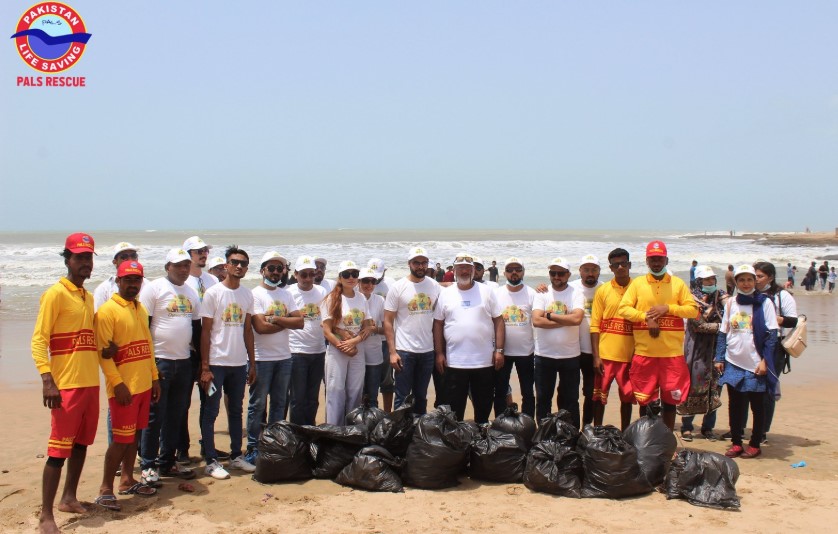 Winter beach cleanup at Karachi's French Beach with volunteers collecting litter to protect the marine ecosystem.